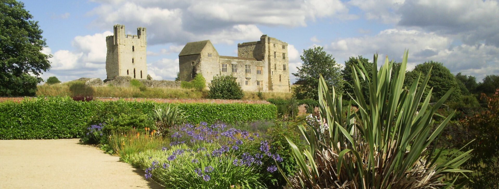 Stately walled gardens with ruins of Helmsley Castle in the background